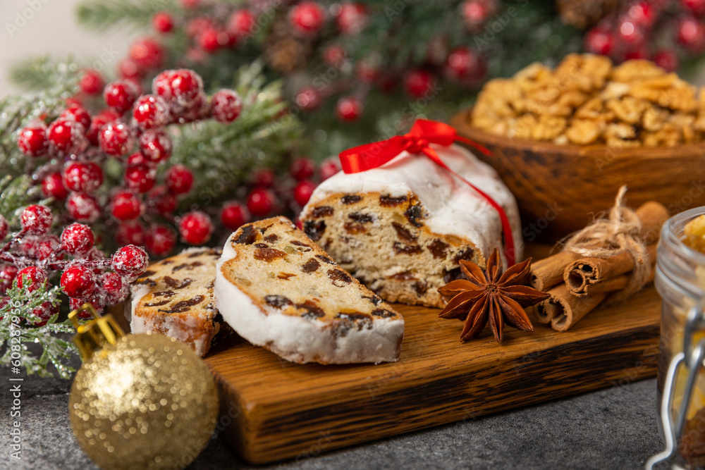 Christmas stollen on wooden background. Traditional Christmas festive pastry dessert. Stollen for Christmas.Christmas fruit cake, pudding on a white plate.Traditional German Christmas pastry.