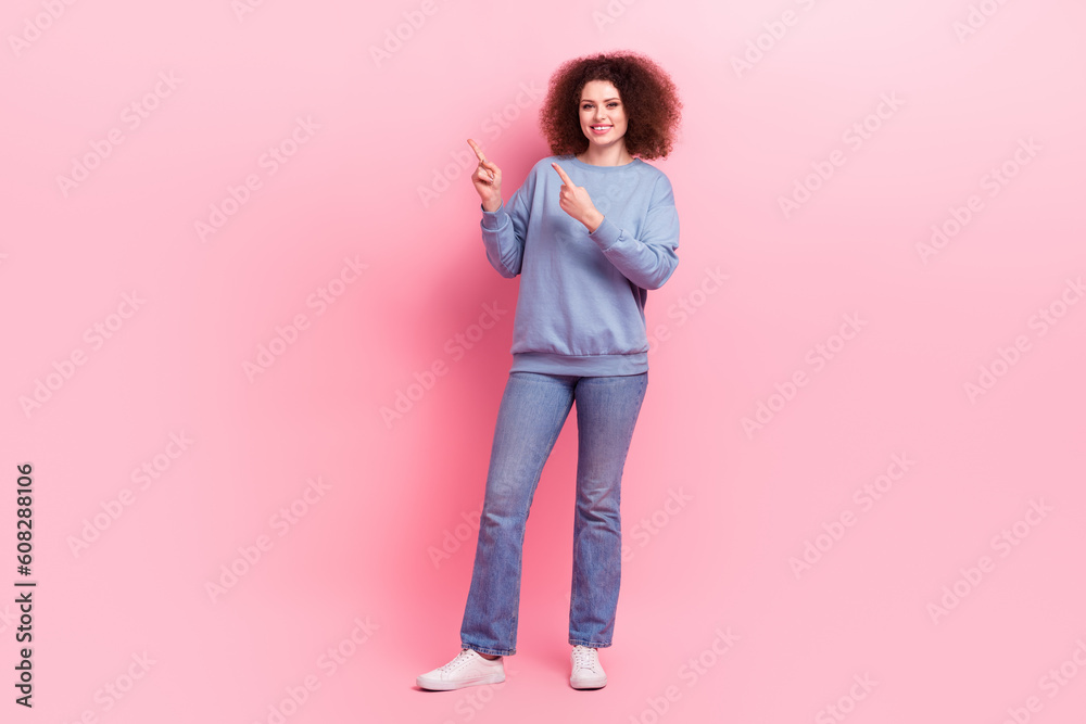 Full body photo of optimistic promoter girl wear blue sweatshirt jeans point fingers mockup brand clothes isolated on pink color background Full body photo of optimistic promoter girl wear blue sweatshirt jeans point fingers mockup brand clothes isolated on pink color background