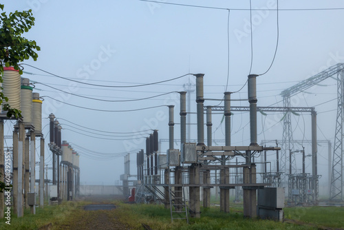 High voltage industrial power plant in the early morning in the fog