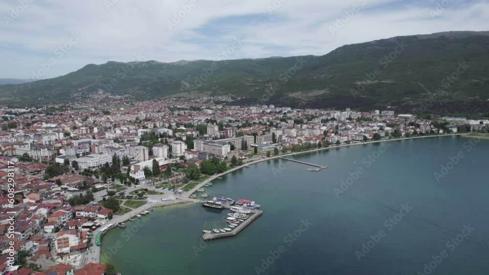 Aerial view of Ohrid. Different sail boats beside dock on ohrid lake with traditional house architecture on background Aerial view of Ohrid. Different sail boats beside dock on ohrid lake with traditional house architecture on background
