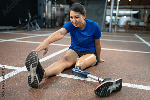 Happy Asia woman with prosthetic leg exercise at gym or fitness 