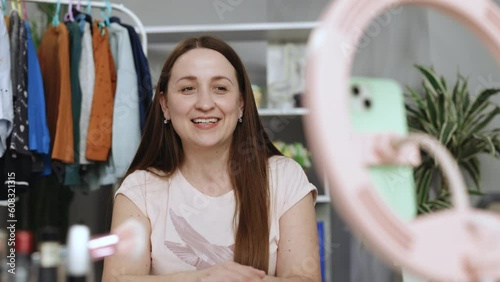 Woman seller broadcast live streaming to sell clothes for online social marketing. Stylist influencer woman with trendy clothes filming vlog episode for her channel. Opinion leader sets trends