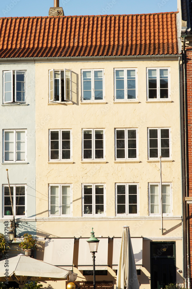 Fototapeta premium Yellow historic terraced house in Nyhavn in the center of Copenhagen in Denmark