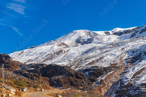 Frozen World. A view of a glacier on the slope of a rock-brown mountain. A white covering of snow on a dark brown landscape gives mesmerizing effect and provides the perfect destination for holidays.