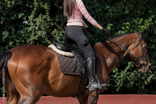 Unrecognizable woman riding a horse in an equestrian center