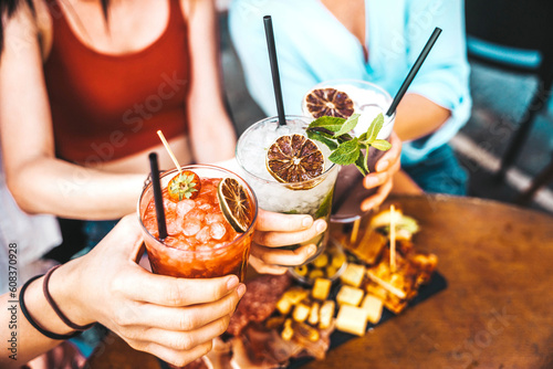 Canvas Print Happy friends clink cocktail glasses at bar restaurant - Young people enjoying h