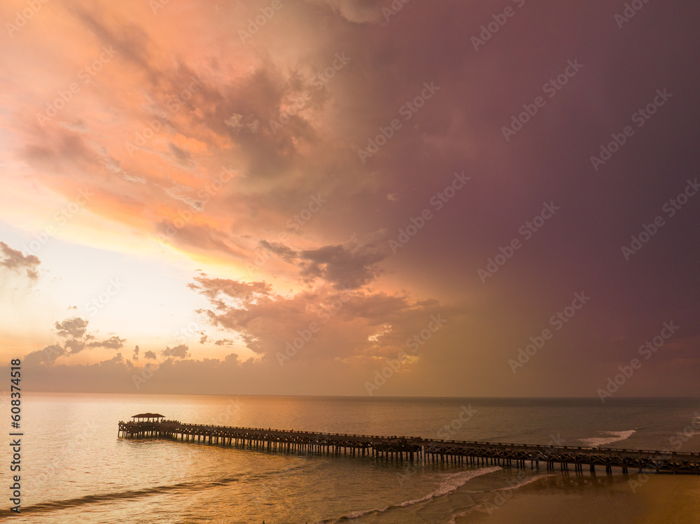 Obraz premium aerial view amazing cloud in colorful sky at sunset above the ocean..The bridge plunges into the sea water reflected from the sky..Majestic sunset landscape Amazing light of nature cloudscape sky..
