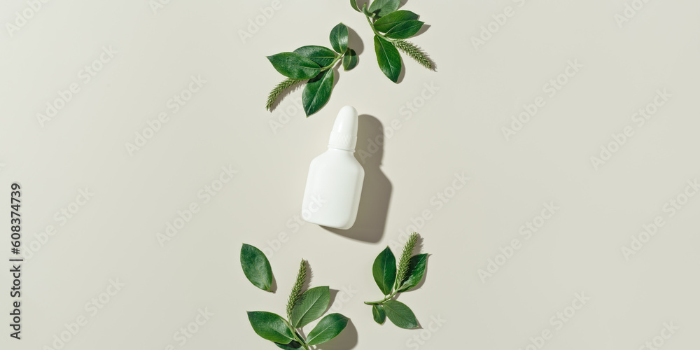 Seasonal allergy concept, spring young branches tree with new green leaves and catkins and white nasal spray on beige background, minimal creative top view, aesthetic flat lay. Healthy lifestyle Seasonal allergy concept, spring young branches tree with new green leaves and catkins and white nasal spray on beige background, minimal creative top view, aesthetic flat lay. Healthy lifestyle