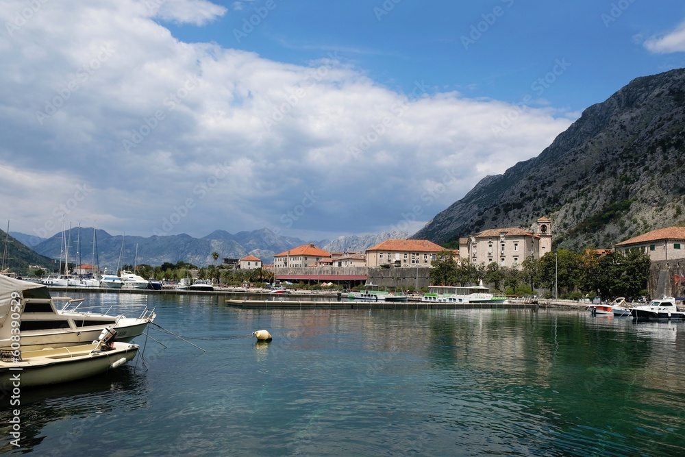 Ancient town Kotor by Bay of Kotor (Boka), Montenegro. Boats on water by coast.