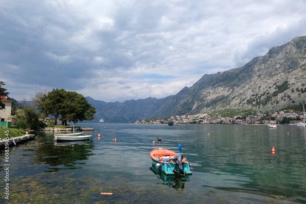 Naklejka premium View of Bay of Kotor with buildings of Kotor and standing big cruise ship by coast from tourist rail on Vrmac Peninsula, with the highest peak Sveti Ilija. Montenegro, Balkans