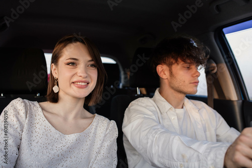 positive couple in love ride in a car on a trip to a date on a sunny day