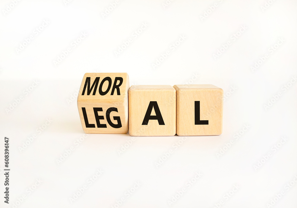 Legal or moral symbol. Businessman turns wooden cubes and changes the word Legal to Moral on a Beautiful white table white background. Business and Legal or moral concept. Copy space. Legal or moral symbol. Businessman turns wooden cubes and changes the word Legal to Moral on a Beautiful white table white background. Business and Legal or moral concept. Copy space.