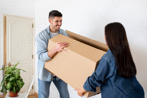 Happy European Couple Carrying Big Cardboard Box With Bellongings At Home