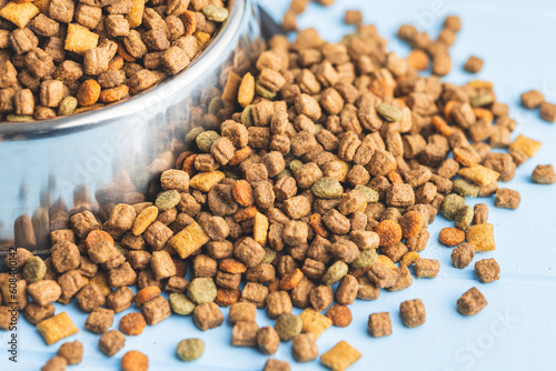 Photographie Dry kibble pet food. Dog or cat food on blue table.