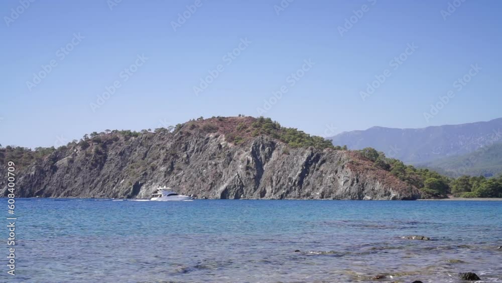 Pleasure boat floats on the sea near the rocky shore. Pleasure boat floats on the sea near the rocky shore.