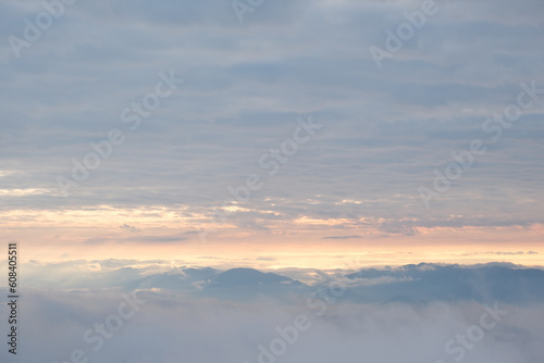 A mountain obscured by white mist at dawn