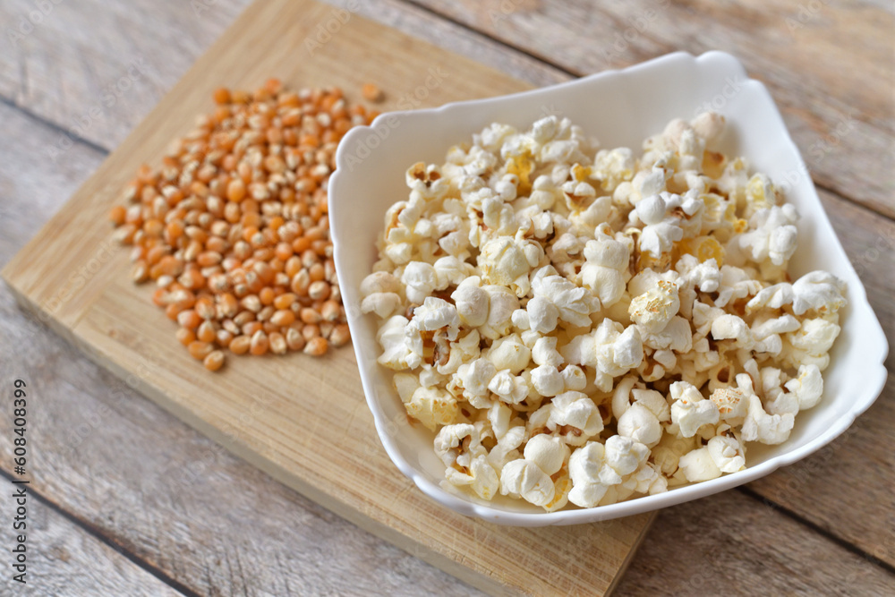 Popcorn home cooking and corn seeds on wooden background Popcorn home cooking and corn seeds on wooden background