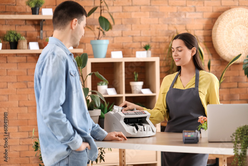 Female cashier using cash c...
