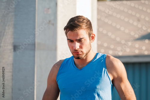 Focused young professional male Caucasian athlete ready for the run race in a sprint starting position