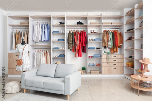 Interior of boutique with stylish clothes, mannequin and sofa © Pixel-Shot