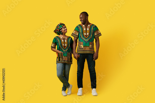 Loving black couple looking at each other on yellow background