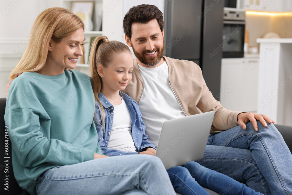 Happy family spending time together and using laptop on sofa at home Happy family spending time together and using laptop on sofa at home