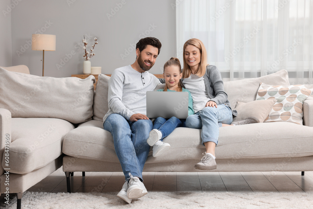 Happy family with laptop on sofa at home Happy family with laptop on sofa at home