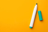 Bright green marker on orange background, flat lay. Space for text
