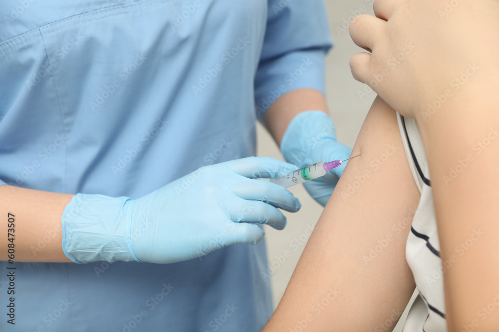 Doctor giving hepatitis vaccine to patient on grey background, closeup