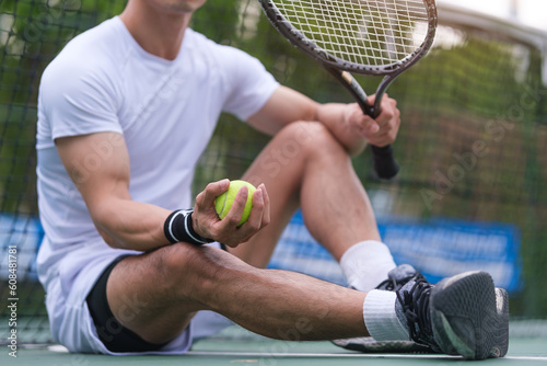 Male tennis player with and ball resting tennis court. Sport, competition and healthy lifestyle concept.