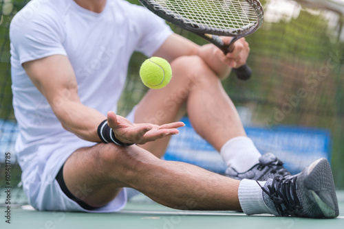 Man in white sports clothes holding racket and ball resting tennis court. Sport, competition, healthy and active lifestyle concept.