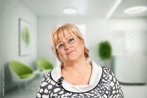Portrait of pensive smiling older lady dreaming at home