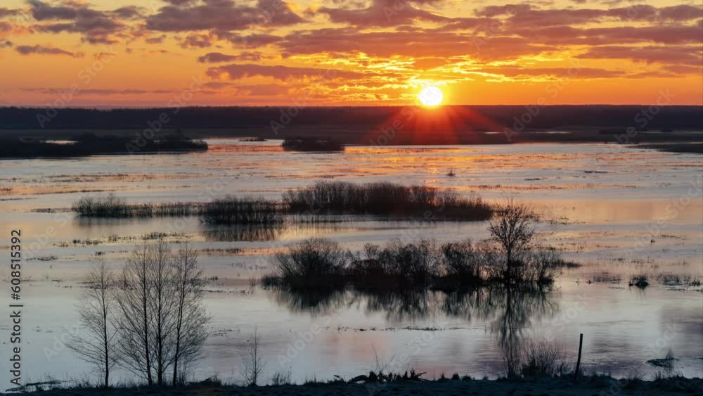 Sun disc rises from behind the horizon over the river Sun disc rises from behind the horizon over the river