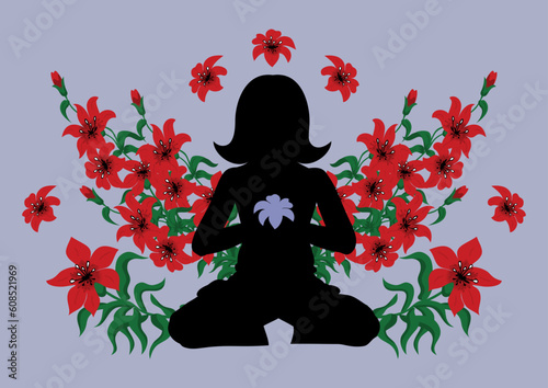 Silhouette of meditating woman surrounded with red lilies