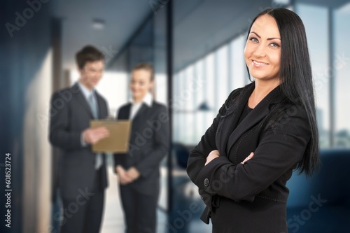 Successful young businesswoman standing in office and posing