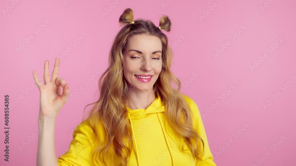 Woman, ok hand, wink and smile excited emotion, sign or symbol feeling happy. Lady with emoji okay gesture and mock up for success, approval, motivation or review, opinion in studio pink background. Woman, ok hand, wink and smile excited emotion, sign or symbol feeling happy. Lady with emoji okay gesture and mock up for success, approval, motivation or review, opinion in studio pink background.