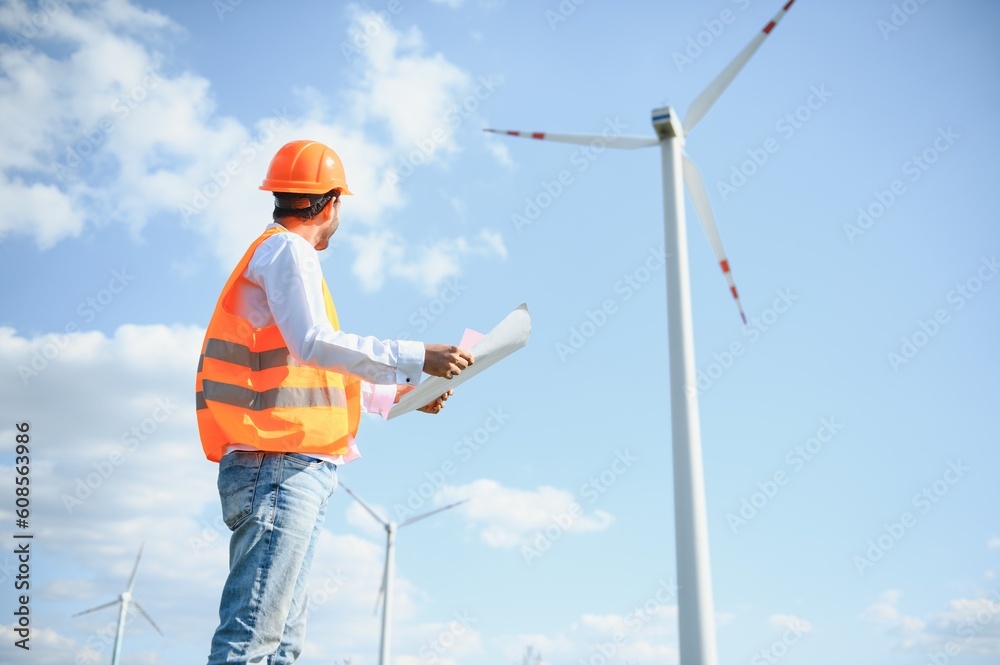 Indian Engineer in wheat field checking on turbine production Indian Engineer in wheat field checking on turbine production