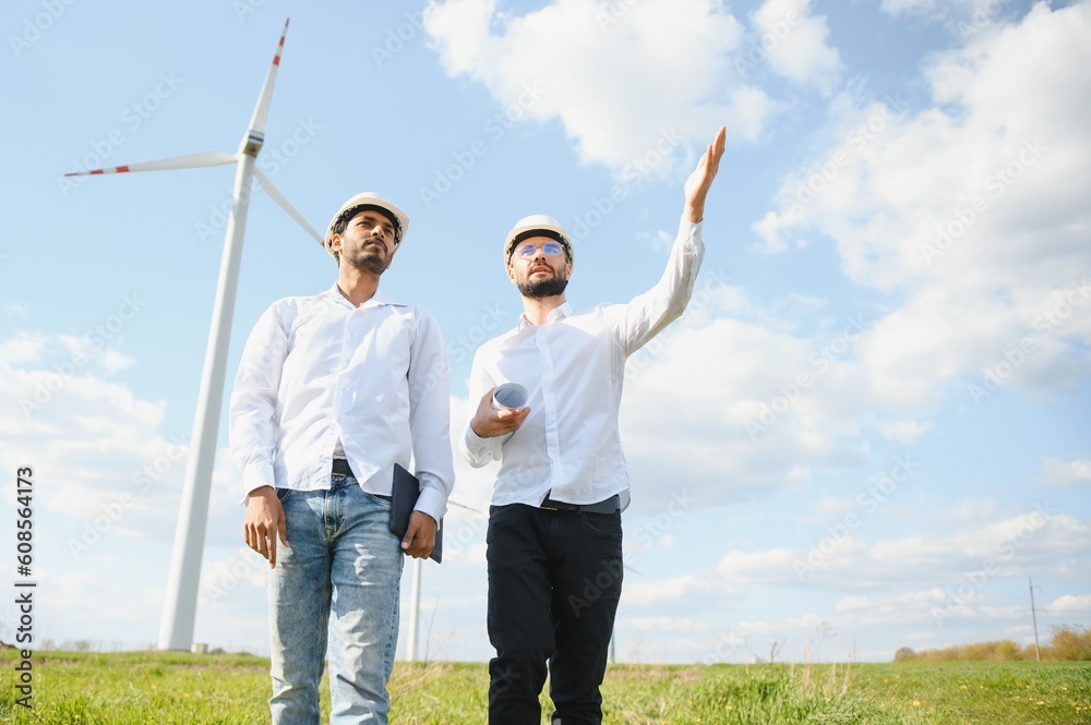 Young maintenance engineer team working in wind turbine farm. Young maintenance engineer team working in wind turbine farm.