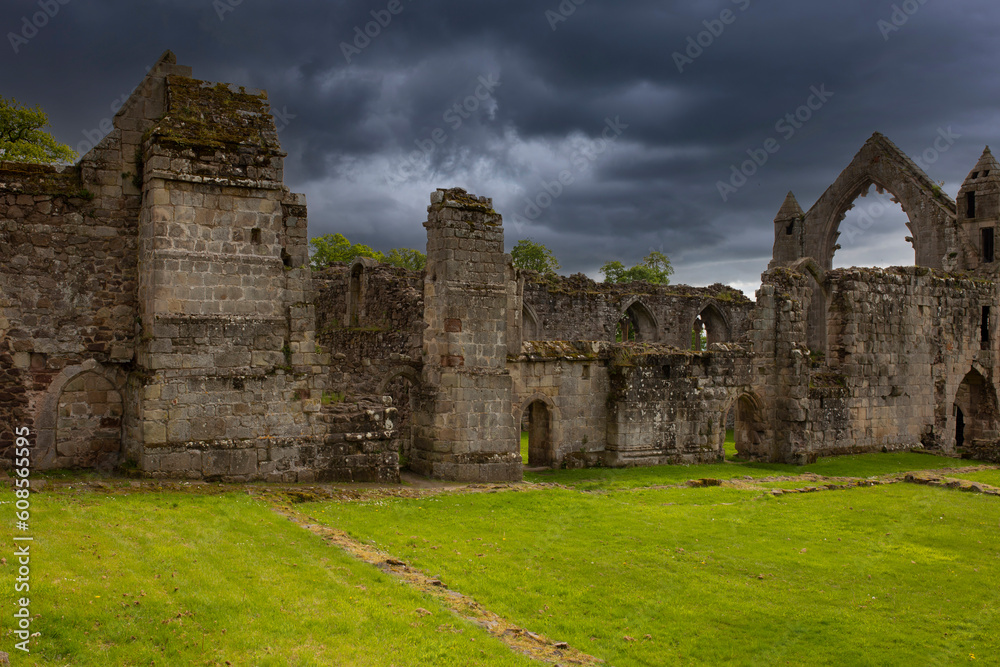 Abbey ruins with storm clouds building in the background. British religious history concept.