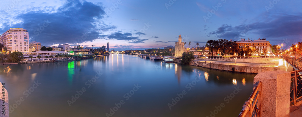 Sunset panorama over Seville, Guadalquivir river and golden tower Torre del Oro.