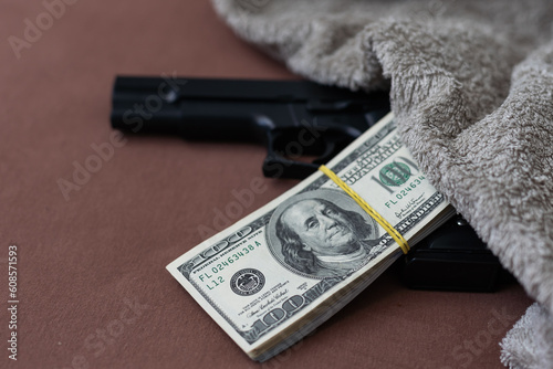 black gun on the background of cash dollars. the concept of criminal money or murder for money. bank robbery, photo