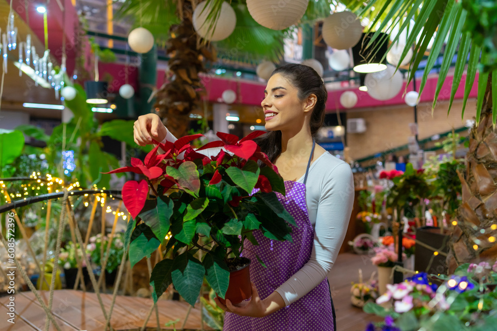 A beautiful florist nurtures flowers in a flower shop