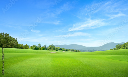 Golf course with mountain and blue sky background.