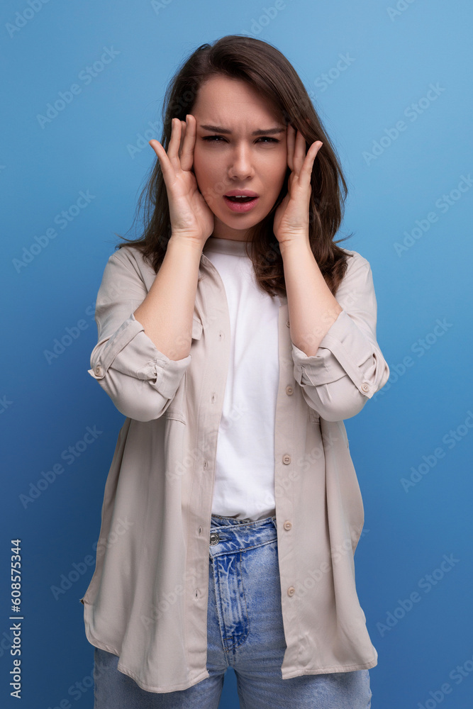 pretty young brunette female adult in casual shirt with headache pretty young brunette female adult in casual shirt with headache