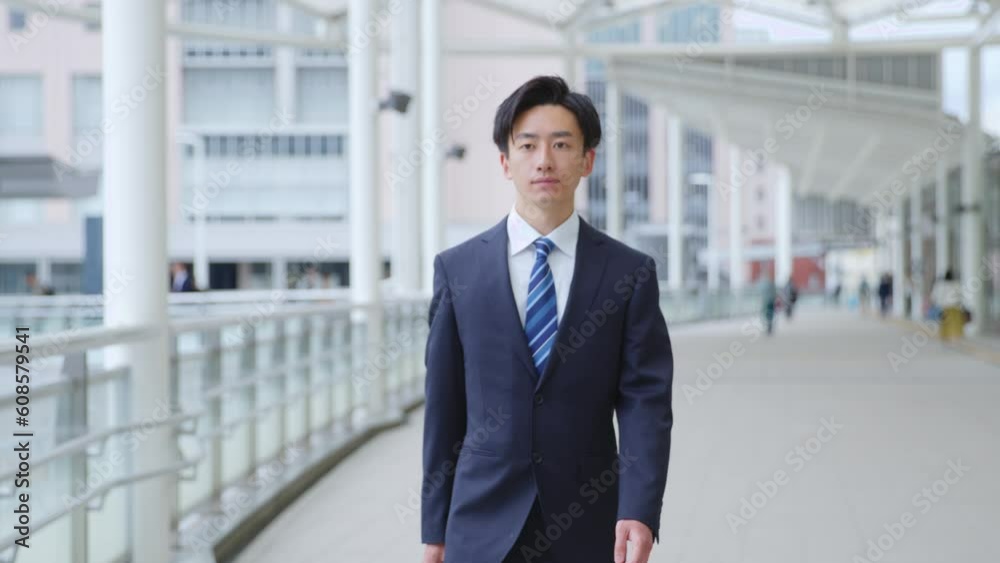 スーツを着て歩く若い日本人ビジネスマンのスローモーションイメージ スーツを着て歩く若い日本人ビジネスマンのスローモーションイメージ