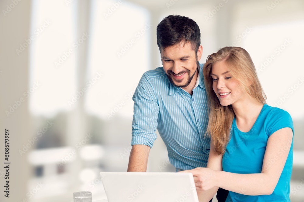Two cheerful office workers work with laptop, Two cheerful office workers work with laptop,