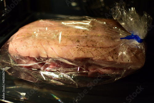 Norwegian traditional hot Christmas dish ribbe in a roasting pan for baking in the oven with steam