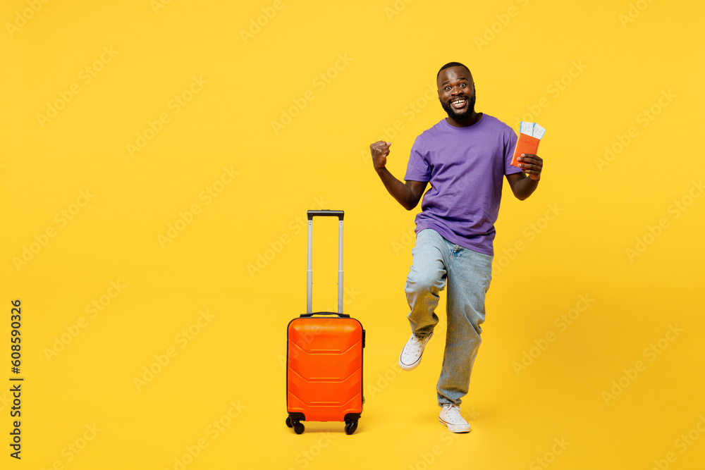 Traveler winner man wear casual clothes t-shirt hold passport ticket suitcase isolated on plain yellow background Tourist travel abroad in free spare time rest getaway Air flight trip journey concept Traveler winner man wear casual clothes t-shirt hold passport ticket suitcase isolated on plain yellow background Tourist travel abroad in free spare time rest getaway Air flight trip journey concept