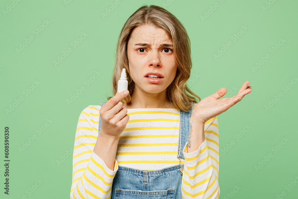 Sick unhealthy ill allergic sad woman has red watery eyes runny stuffy sore nose suffer from allergy trigger symptoms hay fever use nasal spray spread hand isolated on plain green background studio. Sick unhealthy ill allergic sad woman has red watery eyes runny stuffy sore nose suffer from allergy trigger symptoms hay fever use nasal spray spread hand isolated on plain green background studio.