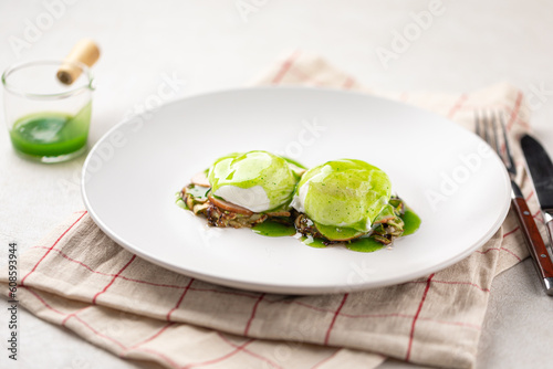 Portion of gourmet breakfast with poached egg and green sauce